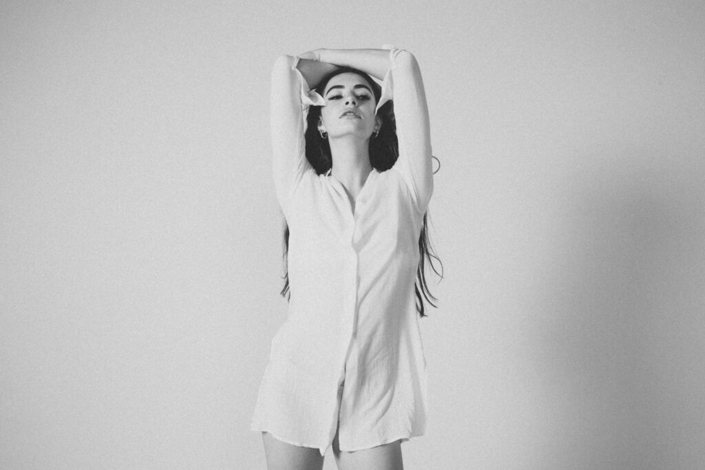 A woman standing in front of a white wall